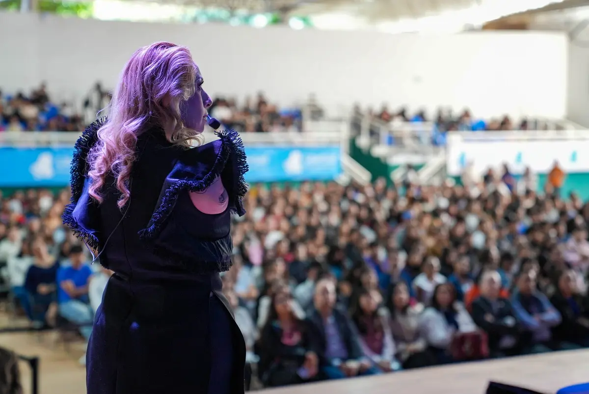 Adriana Macías frente a un auditorio con cientos de asistentes